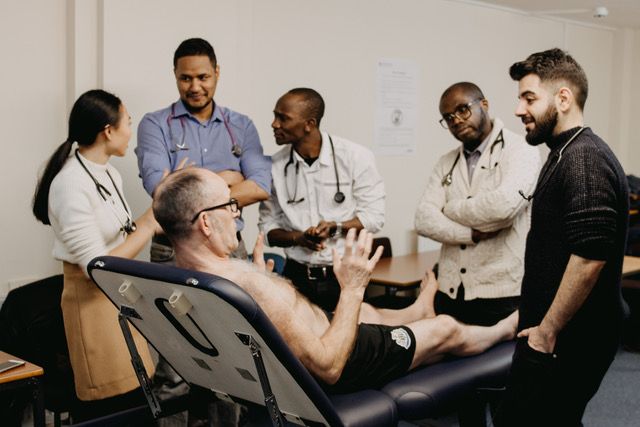 Image of Bob ACE working with a group of physician associate students at a recent training course