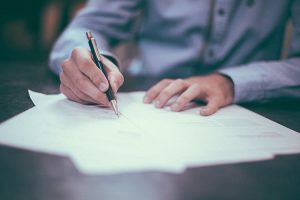 Image of man writing on exam paper